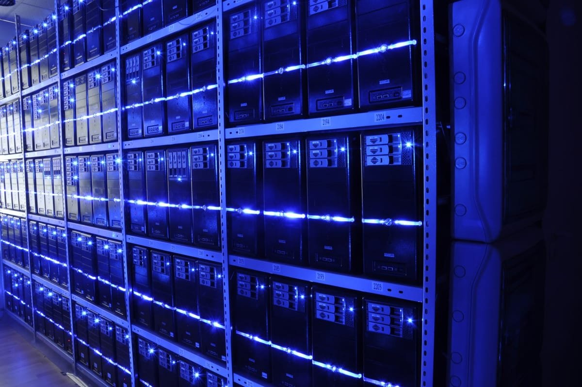 Corredor de data center com racks de servidores acesos